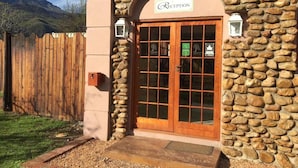 A stone building with a reception area, wooden door, and a stone wall.