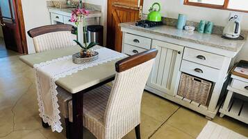 Una cocina con una mesa de comedor, sillas y una ventana.