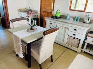 Een keuken met een eettafel, stoelen en een raam.