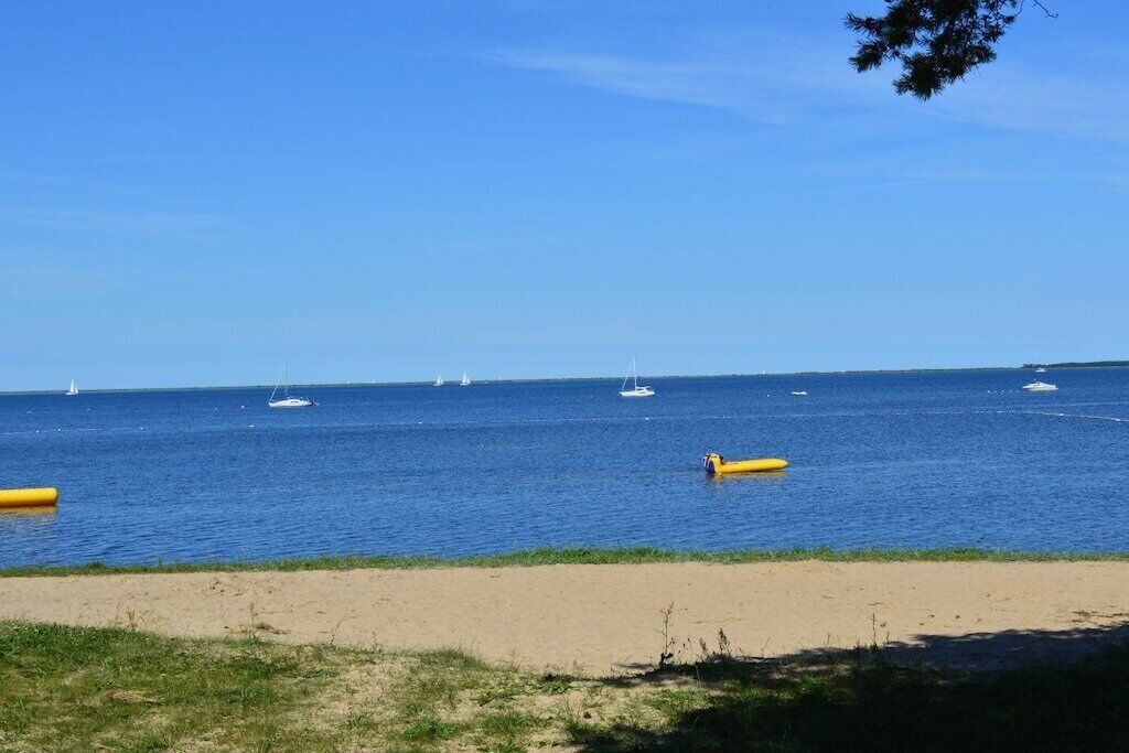 A beach with a clear sky, calm sea, and a sandy shore.