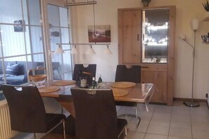 Ein Essbereich mit einem Holztisch, schwarzen Stühlen und einer Glasvitrine.