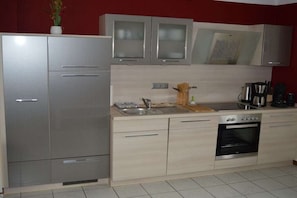 Eine Küche mit Kühlschrank, Backofen und Spüle.