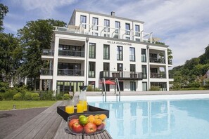 A modern villa with a pool, surrounded by greenery. - Paradise Cloud at Villa Augustine (Ostseebad Binz)