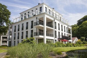 A multi-story building with balconies, a name plaque, and a garden area. - Paradise Cloud at Villa Augustine (Ostseebad Binz)