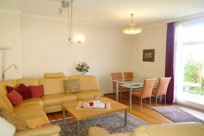 Ein Wohnzimmer mit einer Couch, einem Couchtisch und einem Essbereich mit Stühlen.