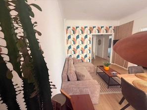 Ein modernes Wohnzimmer mit einer Couch, einem Couchtisch und einem Essbereich mit Tisch und Stühlen.
