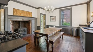 Une cuisine avec une table en bois, un banc et une cheminée.