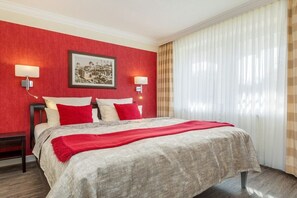 A hotel room with a bed, two bedside lamps, a framed picture on the wall, and a window with curtains. - Dream time at Villa Freia (Binz)
