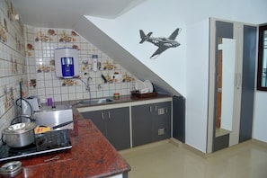 A kitchen with a red granite countertop, a coffee maker, and a wall-mounted airplane decal.