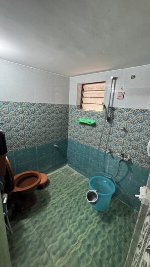 Et badeværelse med toilet, bidet og bruseområde.