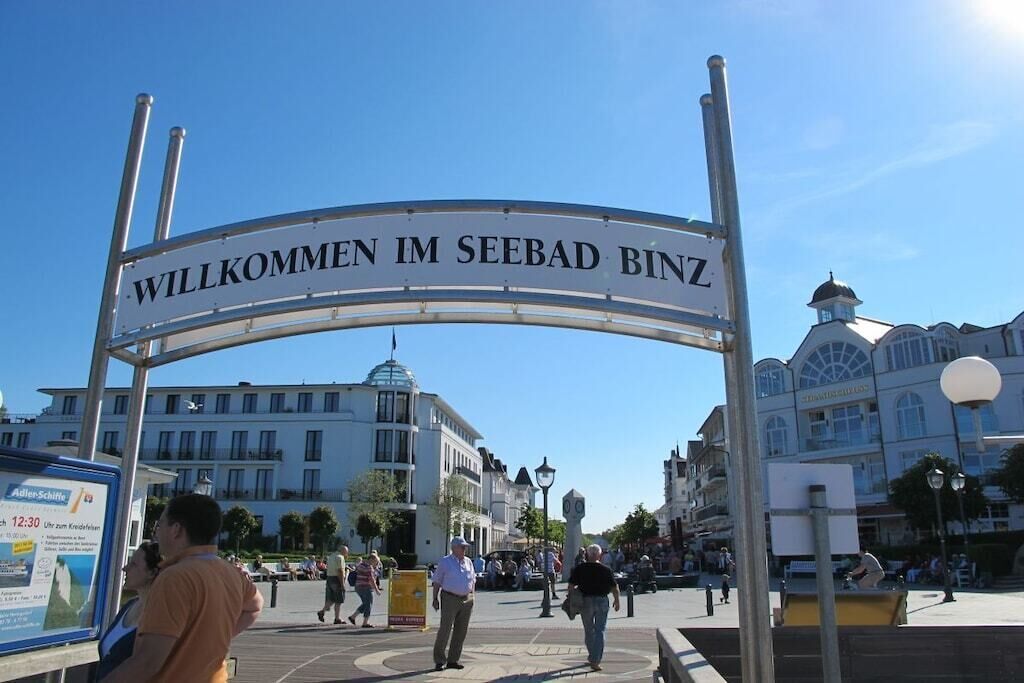 Ein Willkommensschild auf einem öffentlichen Platz, im Hintergrund sind Gebäude zu sehen.