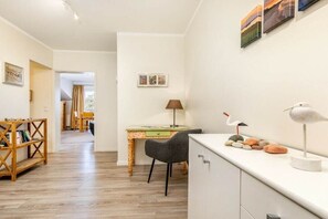Une pièce comprenant un bureau, une chaise, une bibliothèque et des objets de décoration.