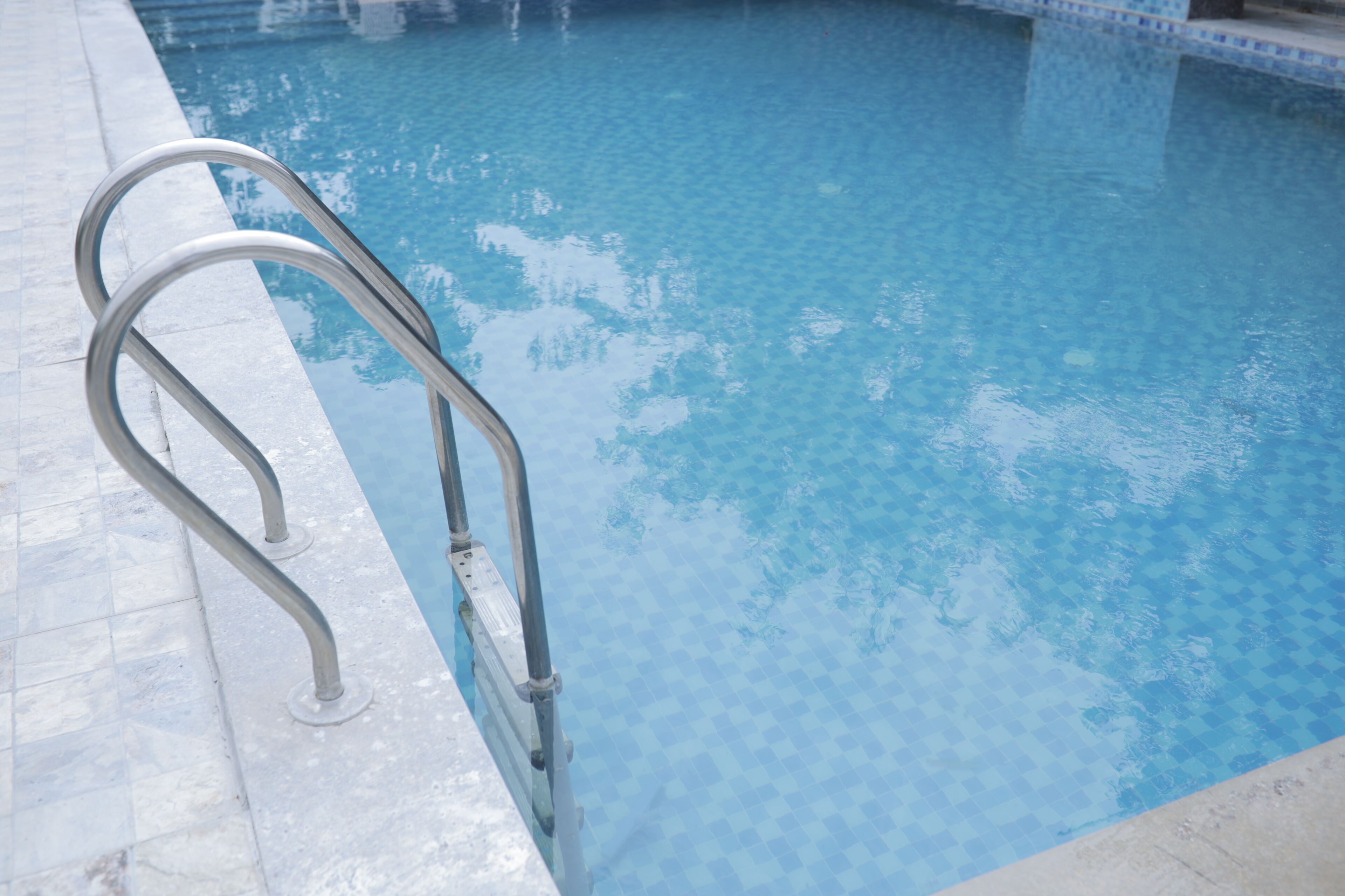 A swimming pool with a metal ladder on the left side.