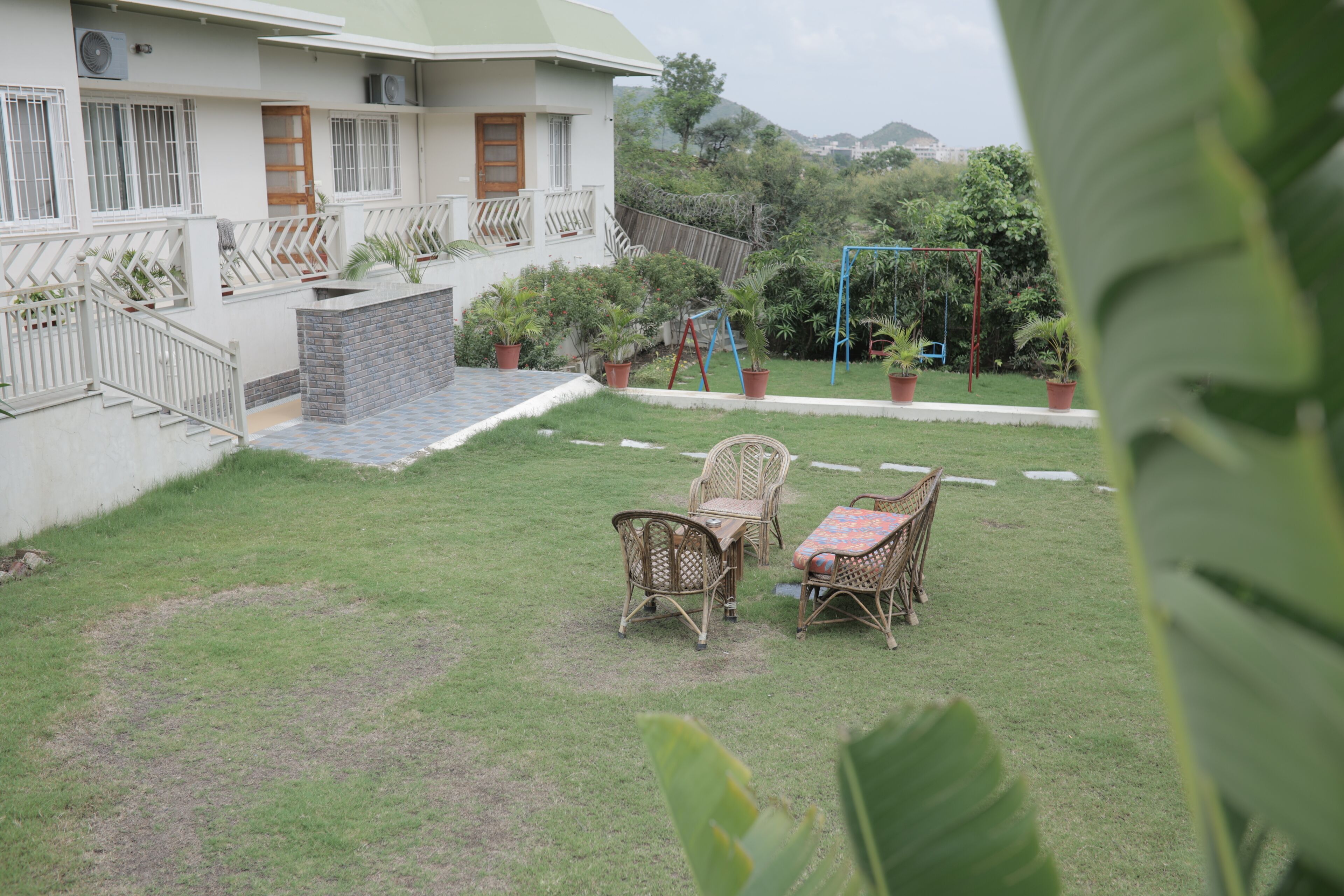 A residential property with a fenced backyard, outdoor furniture, and a swing set.