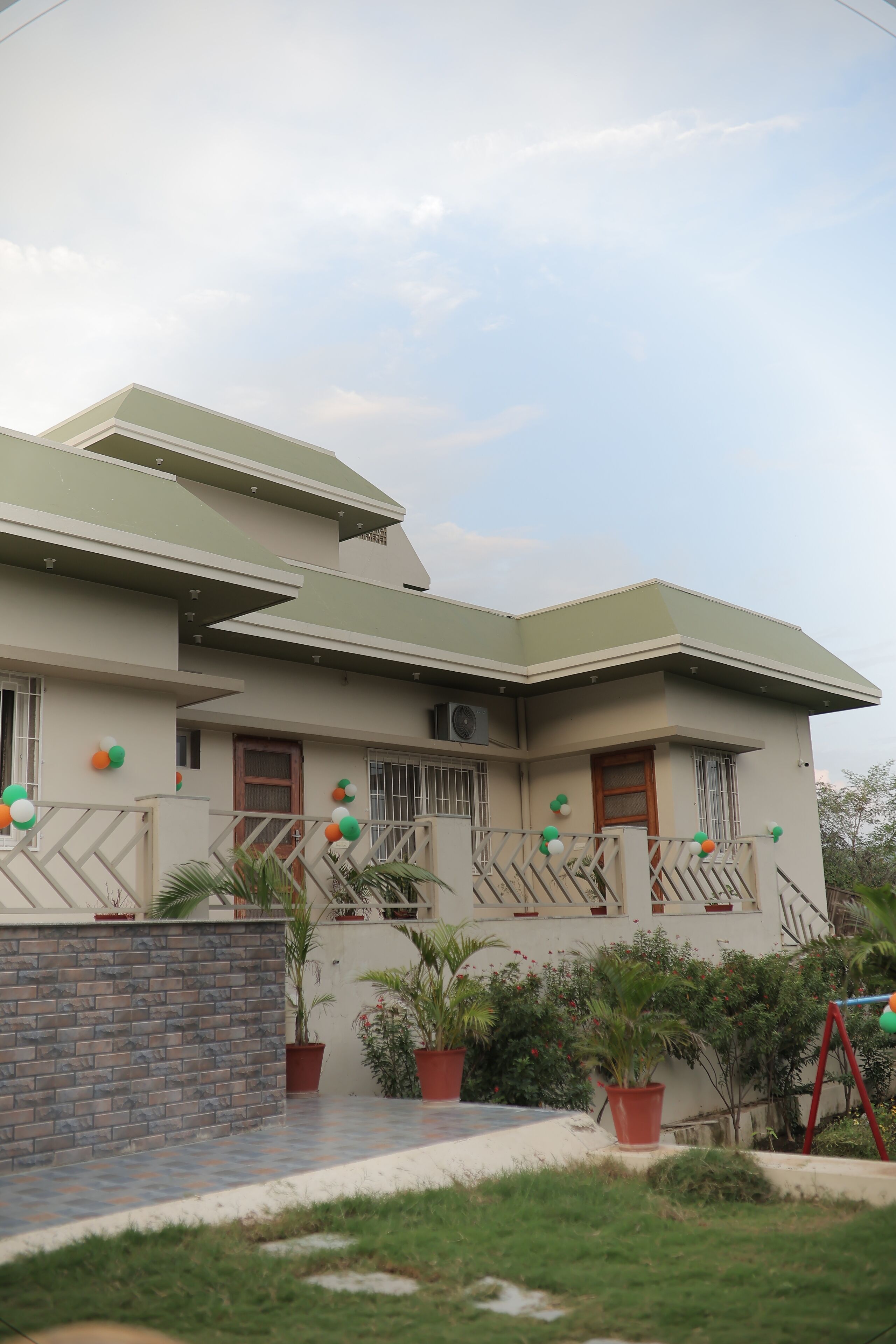 A two-story building with a flat roof and a balcony.