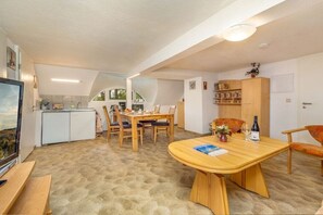 A compact kitchen with a dining area, a television, and a view of the outdoors. - Holiday apartment with 2 bedrooms (Haide\/Ummanz)