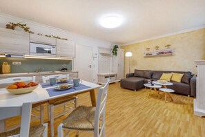 A compact living space with a kitchenette, dining area, and a sofa. - "Nymph" in the Villa Frigga (Binz)