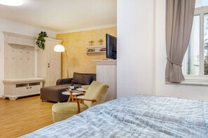 A room with a bed, a desk, a chair, a wardrobe, and a television. - "Nymph" in the Villa Frigga (Binz)