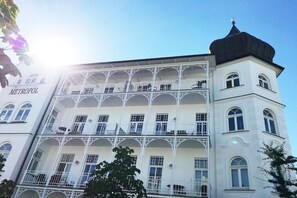 A multi-story building with balconies, a sign reading 'METROPOL', and a dome on the top right. - Holiday apartment in Binz with swimming pool (Binz)