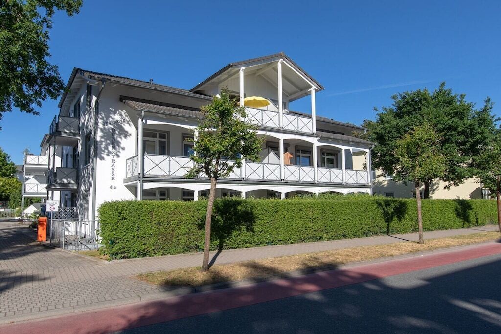 A two-story building with a balcony and a covered area.