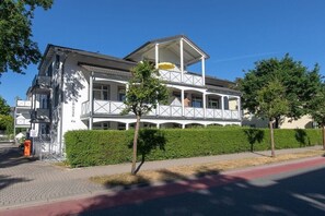 A two-story building with a balcony and a covered area. - 13, Residence Dünenstraße (Binz)