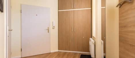 A room with a white door, wooden wardrobe, and a radiator.