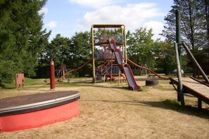 A playground with a slide and climbing structures. - Hof Freitag Geestequelle (Hipstedt)