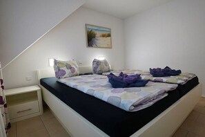 Ein Schlafzimmer mit einem Bett, Nachttischen und einem Bild an der Wand.