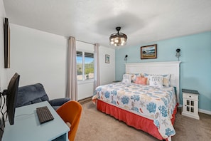 A bedroom with a bed, a desk with a computer, a chair, a window with curtains, and a ceiling fan. - Lincoln City Amazing View Retreat: Hot Tub, Arcade Room, Steps to Beach (Lincoln City)