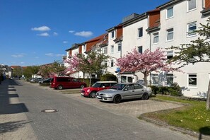 A residential street with parked cars and houses with red roofs. - Holiday apartment with 1 bedroom (Neubrandeburg)
