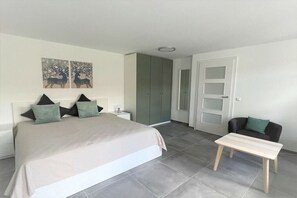 A bedroom with a bed, bedside tables, a chair, and a wardrobe. - Holiday apartment with 1 bedroom (Neubrandeburg)