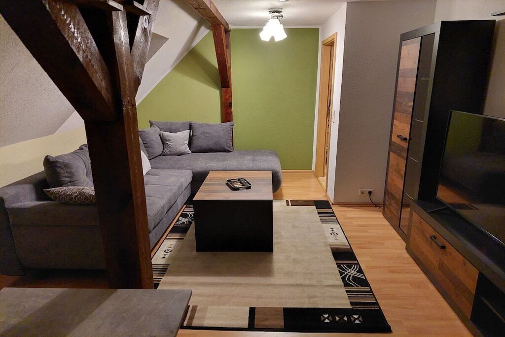 A modern living room with a sofa, a coffee table, and a television.