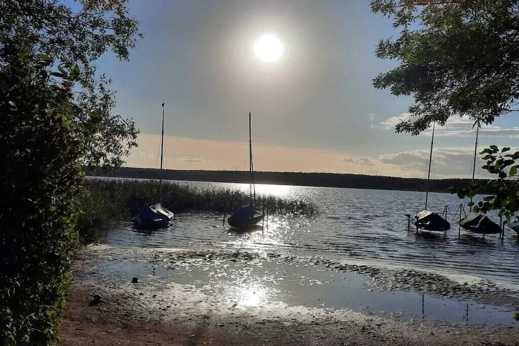 A calm lake with boats and a clear sky.