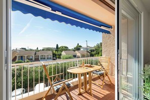 A balcony with a table, chairs, and a view of houses. - Apartment L’Azur Bandolaise by Sur la mer (Bandol)