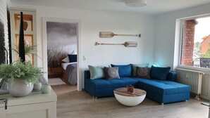 Un saló modern amb un sofà modular, una taula baixa i objectes decoratius.