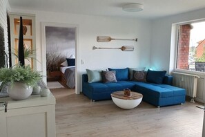 Ein modernes Wohnzimmer mit einer Eckcouch, einem Couchtisch und Dekorationselementen.