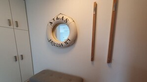 Una habitació amb un objecte rodó a la paret, una banca i una porta de fusta.