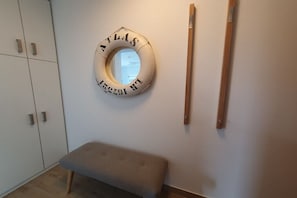 Ein Zimmer mit einem runden Gegenstand an der Wand, einer Bank und einer Holztür.