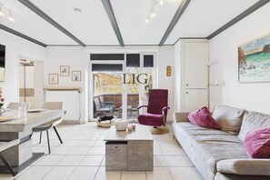 Ein modernes Wohnzimmer mit einer Couch, einem Couchtisch und einem Essbereich mit Stühlen.