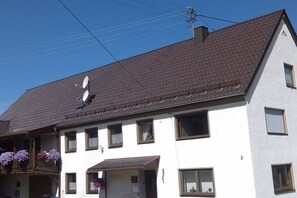 Un bâtiment à deux étages, doté d’un toit en pente, de nombreuses fenêtres et d’antennes paraboliques.