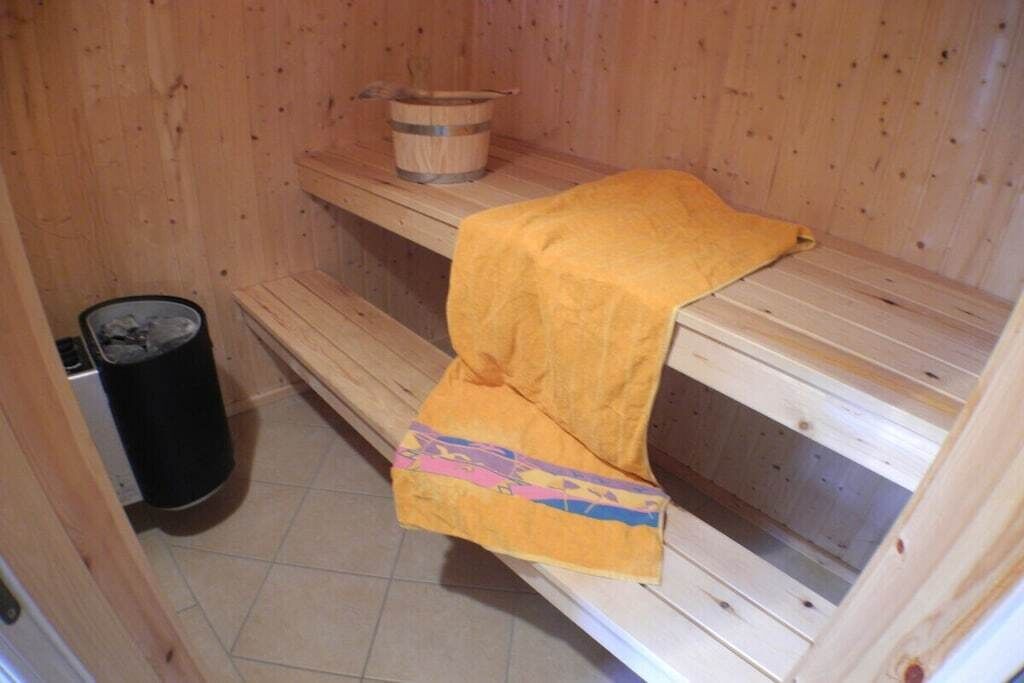 A sauna with wooden benches and a bench with a yellow towel.