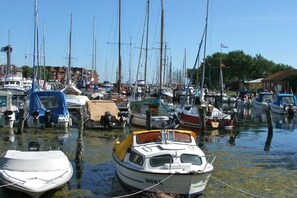 A marina with various boats docked, including a white motorboat with 'MONA' written on it. - Holiday apartment with 1 bedroom (Fehmarn)
