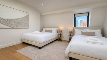 A hotel room with two beds, a city view, and a modern design.