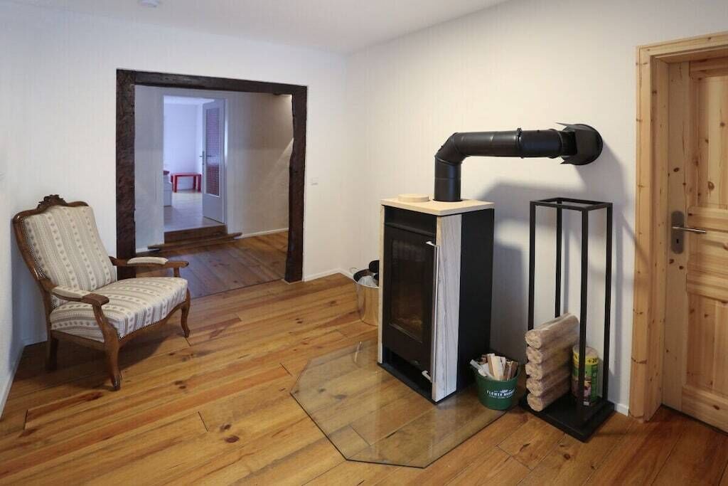 A room with a fireplace, a wooden chair, and a door.