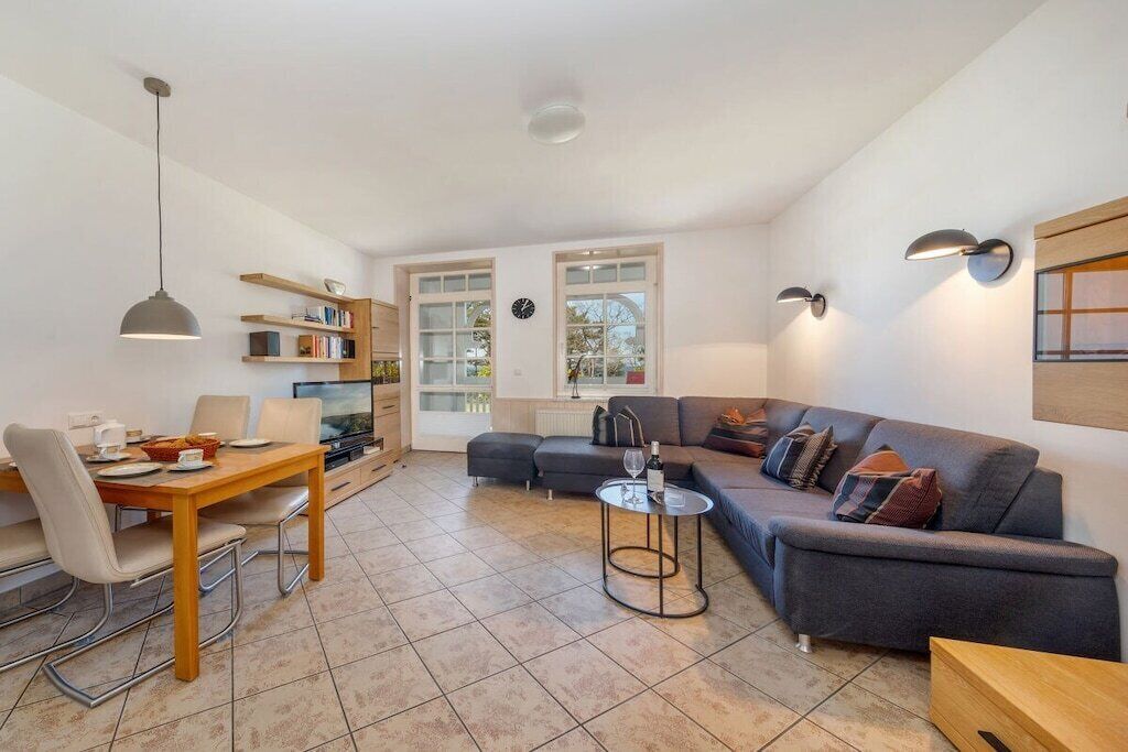 A modern living room with a sofa, dining table, and a TV.