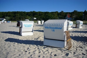 Beachside beach chairs labeled 'Villa Stranddistrikt' with numbers indicating their position. - Beach Whispers (Sea View) (Binz)