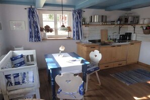 A cozy kitchen with wooden cabinets, a dining table, and chairs. - Holiday apartment with 1 bedroom (Rechenberg-Bienenmühle)