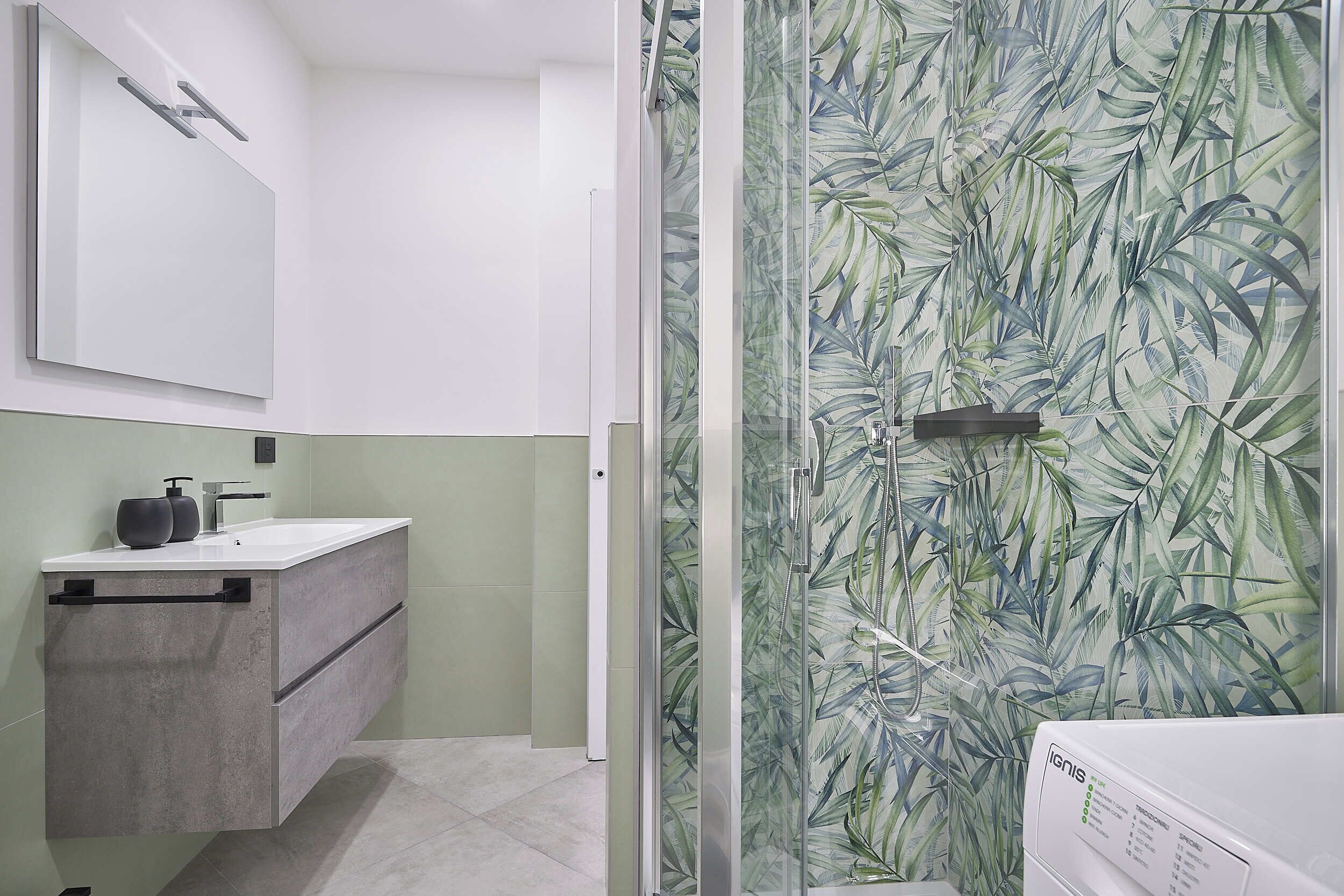 A bathroom with a modern sink, a mirror, and a shower with a glass door.