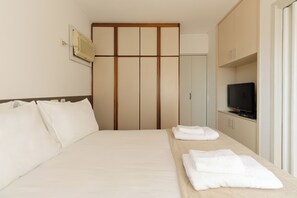 Ein Hotelzimmer mit einem Bett, einem Fernseher und einem Kleiderschrank.