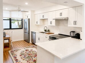 A modern kitchen with white cabinetry, stainless steel appliances, and a large island. - 2 bedroom 2 bath Luxury Bayfront condo on Longboat Key (Longboat Key)